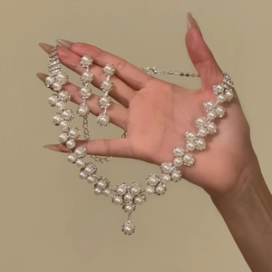 Elegant silver necklace and earrings set featuring white pearls and sparkling diamonds