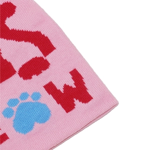 Close-up of pink knit beanie showing texture with red W letter and blue cat paw pattern