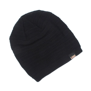 Close-up detail of black knitted beanie showing textured rib pattern and LEOS label