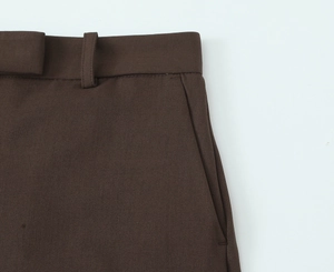 Detailed close-up of brown trousers waist design with high-quality twill fabric texture