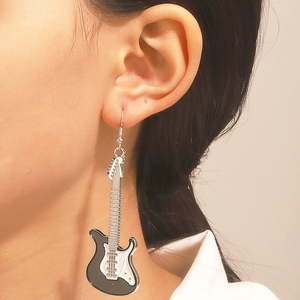 Dettaglio degli orecchini a forma di chitarra elettrica bicolore con texture rifinita