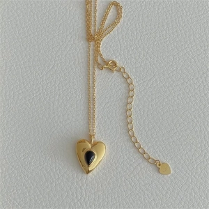 Close-up of S925 sterling silver heart necklace with black teardrop stone inlay