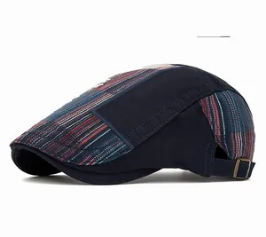 Detail of navy patchwork flat cap with adjustable metal buckle and striped fabric panels