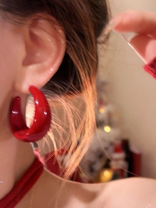 Gros plan de boucles d'oreilles créoles C rouges en acrylique sur un mannequin