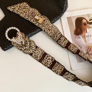 Leopard print waist chain with rhinestone butterfly buckle over a black bag