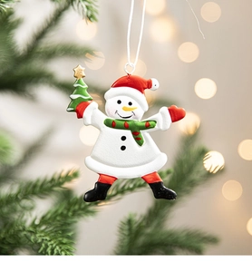 Detail of painted snowman ornament with red hat hanging on a Christmas tree branch