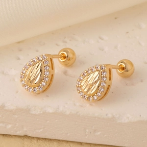 Elegant gold drop earrings with sunburst texture and white zircon halo on stone surface