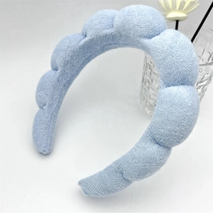 Close-up of light blue puffy sponge headband with textured knit fabric and segmented design
