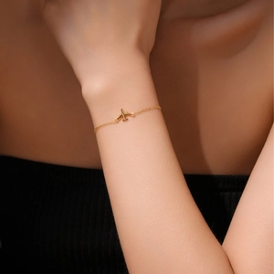 Minimalist s925 silver airplane pendant bracelet in gold finish worn by a model