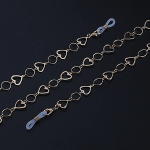 Detailed macro view of gold eyewear chain featuring hollow heart links and silicone loops