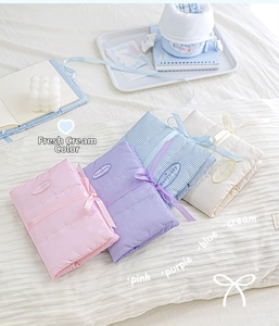 Quilted fabric journals in pink, purple, blue, and cream with ribbon bow closure detail