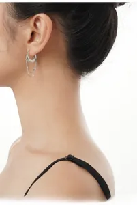 Detail of S925 sterling silver hoop earrings with irregular lava texture and long tassels