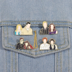 Detail of four cartoon enamel pins attached to a denim jacket pocket for accessory styling