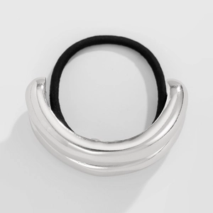 Close-up of a U-shaped silver polished metal ornament on a thick black elastic hair tie