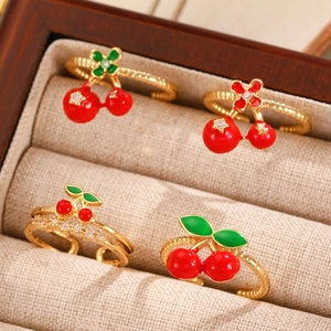 Macro shot of cherry-shaped adjustable rings with red enamel and sparkling stones