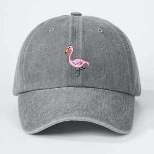 Detail of pink flamingo embroidery on washed gray cotton fabric of the baseball cap