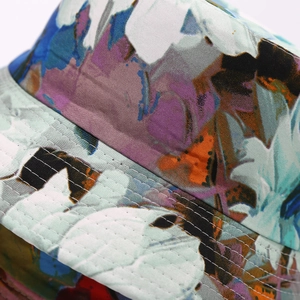 Detail of floral bucket hat showing precise multi-row stitching on the reinforced brim