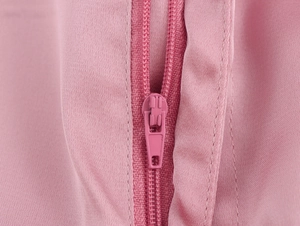 Gros plan détaillé d'une fermeture éclair en nylon rose et de la texture du tissu sergé