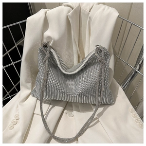 Close-up of sparkling silver rhinestone hobo bag on white blazer for evening style