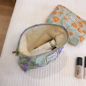 Detailed view of quilted cotton makeup bag featuring floral patterns and secure metal zipper