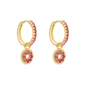 Gros plan détaillé de boucles d'oreilles dorées avec zircons roses et pendentifs fleurs
