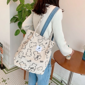 Detail of off-white corduroy tote bag featuring a cute bear print and large capacity