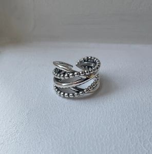 Detail of minimalist 925 sterling silver multi-layer crossover ring with bead accents