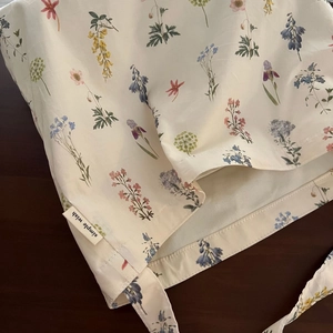 Detail view of cotton tote bag with colorful floral prints and a simple wish side label