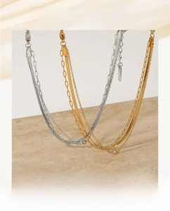 Detail view of multi-layer gold and silver bracelets on light stone decor with zircon pendant