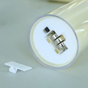 Macro-opname van LED-kaarsbodem met batterijcompartiment en losse witte plastic afdekking