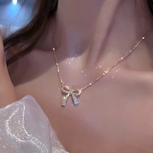Close-up of elegant bow pendant necklace with sparkling cubic zirconia on a model neck