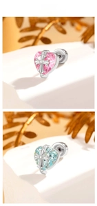 Macro shot of heart-shaped crystal earrings featuring an intricate silver metal cross design