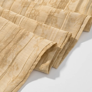 Detailed macro view of champagne gold jacquard fabric with elegant floral textured patterns