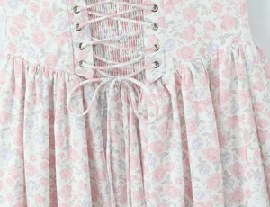 Dettaglio del design a lacci in vita e della stampa floreale su un abito in stile francese