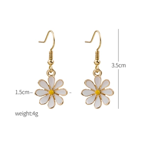 Detail of white daisy earrings with gold hooks and dimensions 3.5cm by 1.5cm