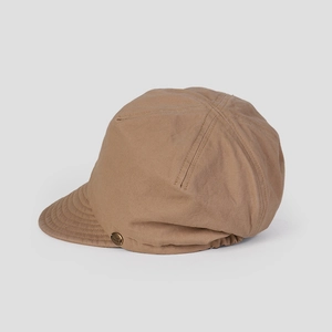 Detail of khaki cotton newsboy cap featuring vintage metal logo and elastic strap