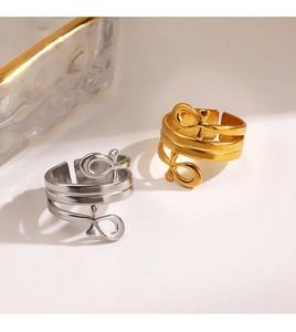 Detail of gold and silver double-layered open rings with minimalist abstract knot design
