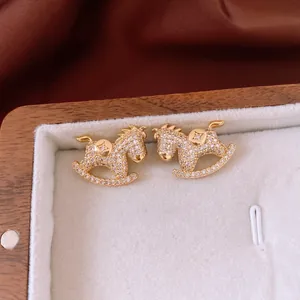 Exquisite gold-plated rocking horse stud earrings with white cubic zirconia crystals