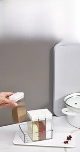 Close-up of a 4-grid transparent seasoning box set with white lids and tray