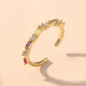 Makro-Detail des goldenen offenen Rings mit bunten Zirkoniasteinen und geometrischem Design