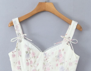 Close-up of floral camisole neckline featuring lace trim and ribbon bow with metal eyelets