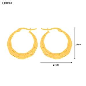 Dettaglio ravvicinato di orecchini a cerchio dorati con trama bambù da 29mm per 27mm
