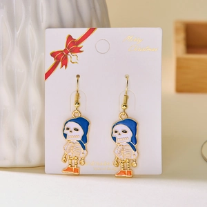 Close-up of enamel skull earrings with floral details and gold hooks on display