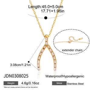 Macro du pendentif wishbone en acier doré 18K avec zircon et détails de la chaîne d'extension