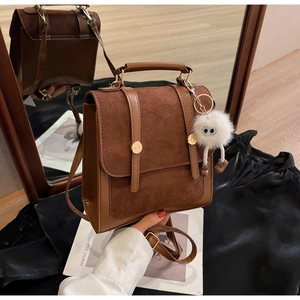 Detail of vintage brown patchwork backpack featuring matte suede and metal buckle detail