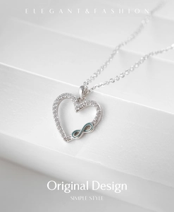 Detail of s925 silver heart necklace with infinity symbol and pave cubic zirconia stones