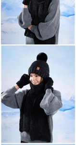 Close-up of black winter knit set showing thick texture and pom-pom detail on snow mountain