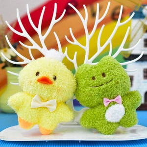 Primo piano di graziosi portachiavi in peluche a forma di papera e rana morbidi.