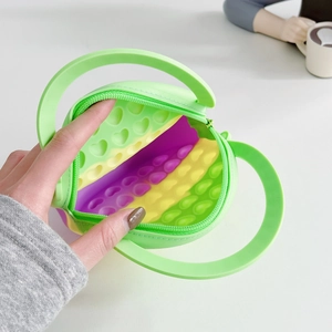 Close-up of heart-shaped silicone pop bag showing green exterior and rainbow bubble interior