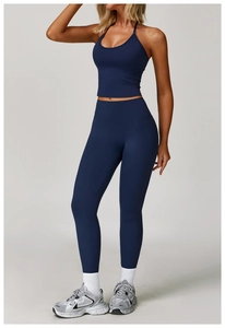 Front view of navy blue halter yoga top and high-waisted leggings set on studio model